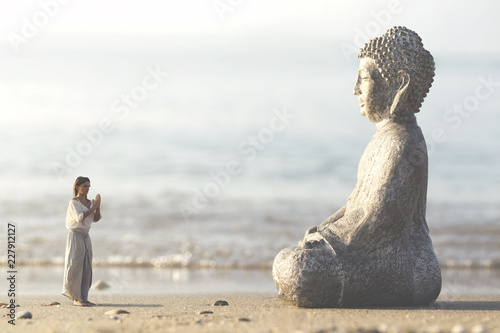 woman prays meditating in front of the Buddha statue photo