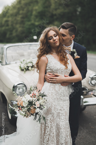 Just married couple in the luxury retro car on their wedding day