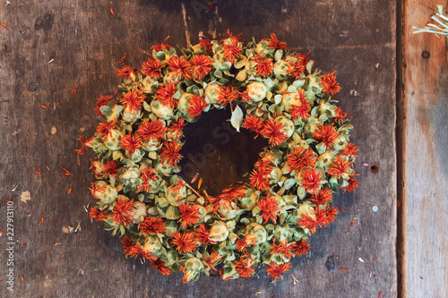 dried red flowers for a wreath at wooden background photo