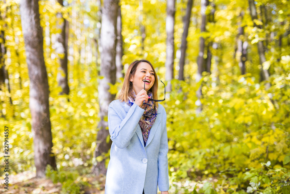 Nature, season and people concept - young woman with sunglasses at the autumn park Nature, season and people concept - young woman with sunglasses at the autumn park