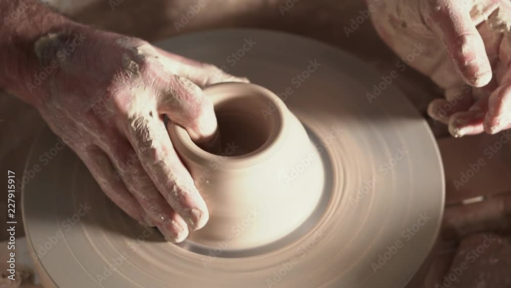 Traditional pottery making, man teacher shows the basics of pottery in art studio. Artist operates hands, which gently creating correctly shaped handmade from clay. Traditional pottery making, man teacher shows the basics of pottery in art studio. Artist operates hands, which gently creating correctly shaped handmade from clay.