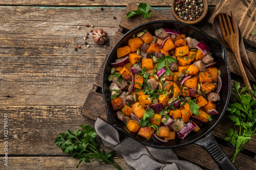 roasted pumpkin with meat on cast iron pan,  rustic backgroun photo