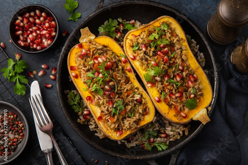 butternut squash stuffed with brown rice and vegetables, served with pomegranate and coriander