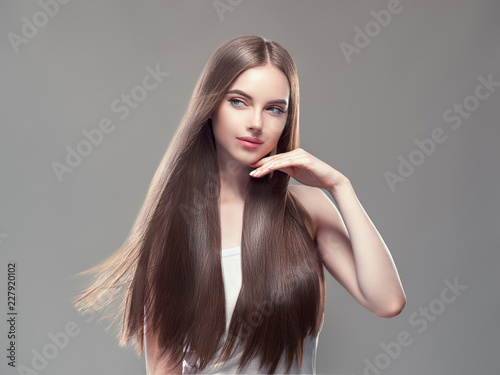 Beautiful long hair smooth brunette dark hair woman over gray background