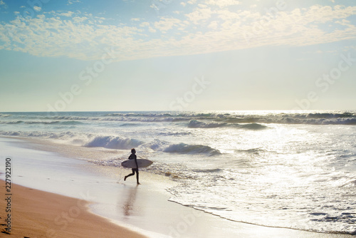 Surfer running to surf