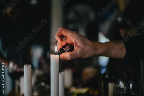 Hand with lighter and a candle with flame 