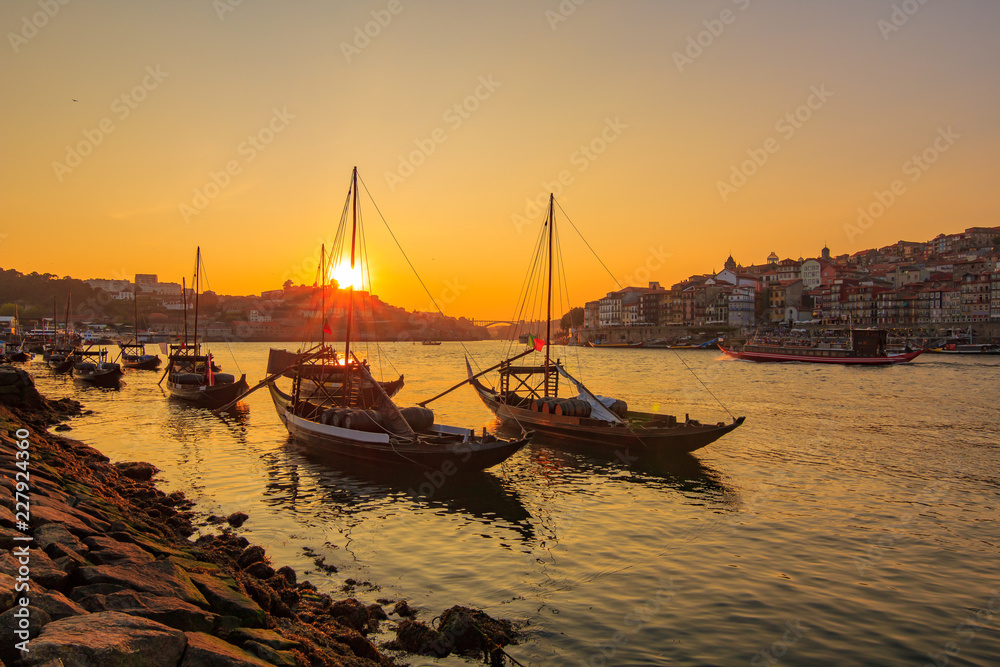 Old town Porto and traditional boats with wine barrels at the sunset time. Portugal.