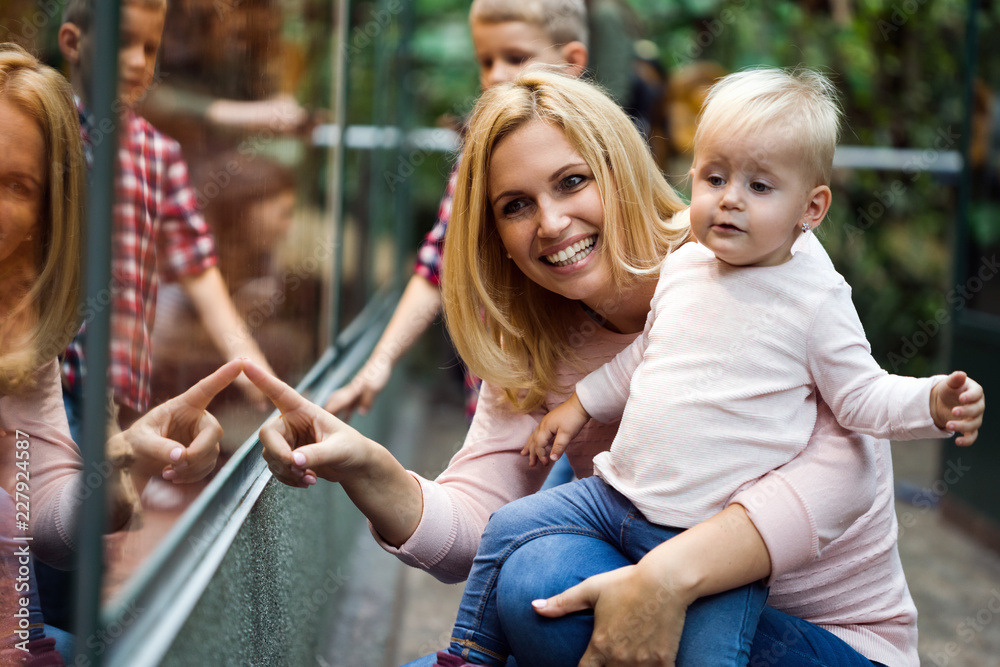 Obraz premium Mother with little girl and boy looking through shop window