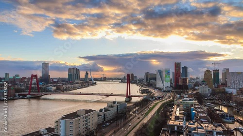 Beautiful 4K UHD cityscape urban timelapse of the skyline of Rotterdam, the Netherlands, with the river Meuse (Maas) and the Erasmus bridge at sunset from day to night photo