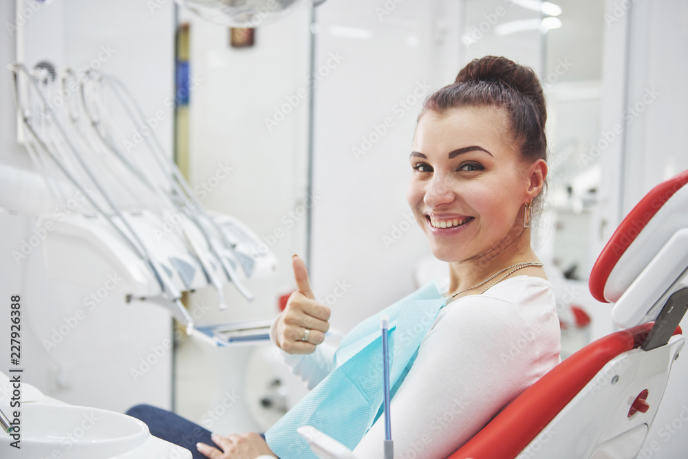 Satisfied patient showing her perfect smile after treatment in a dentist clinic Satisfied patient showing her perfect smile after treatment in a dentist clinic