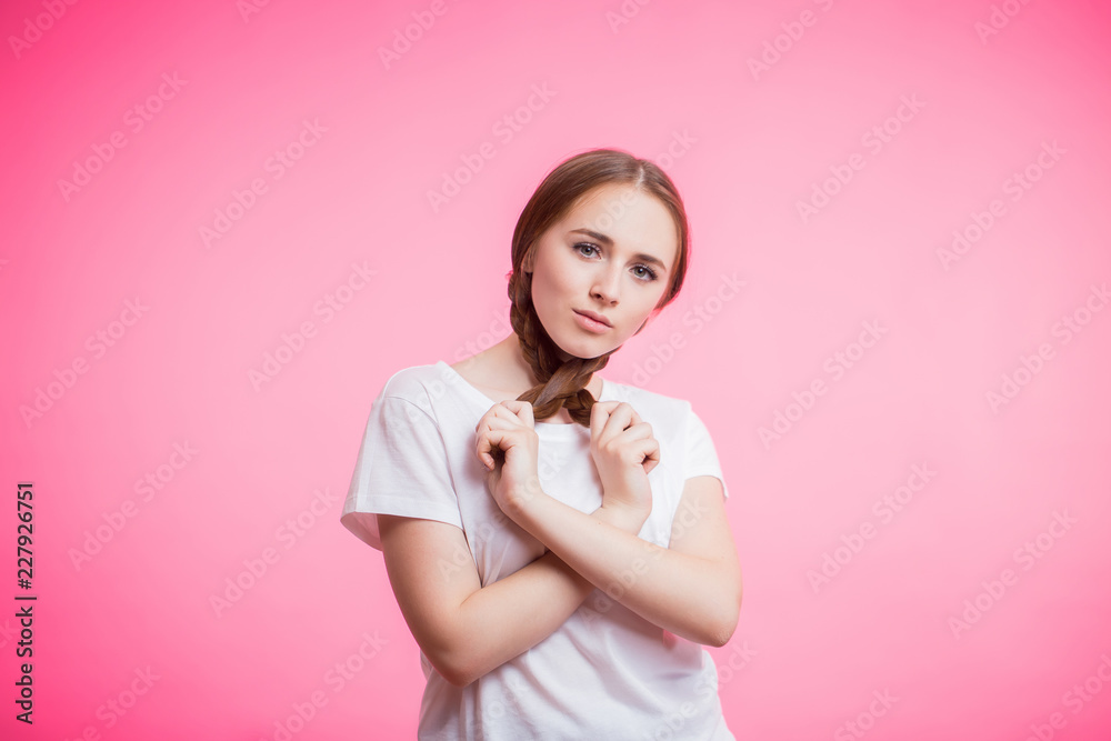 Beautiful portrait of young student girl with pigtails and white t-shirt on pink background Beautiful portrait of young student girl with pigtails and white t-shirt on pink background