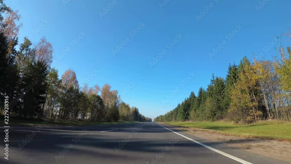 The car goes on an autumn rural road. The car goes on an autumn rural road.