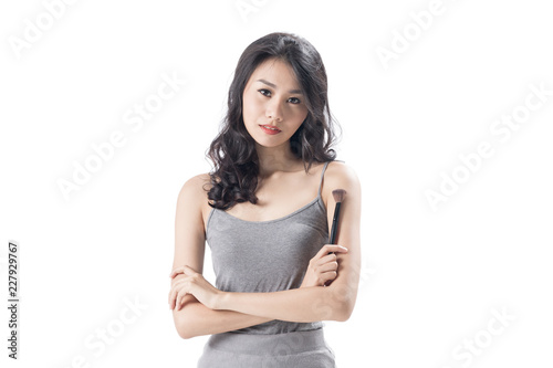 Cheerful young woman wearing light dress standing and posing on isolates white background.Lady holding pink flower. photo