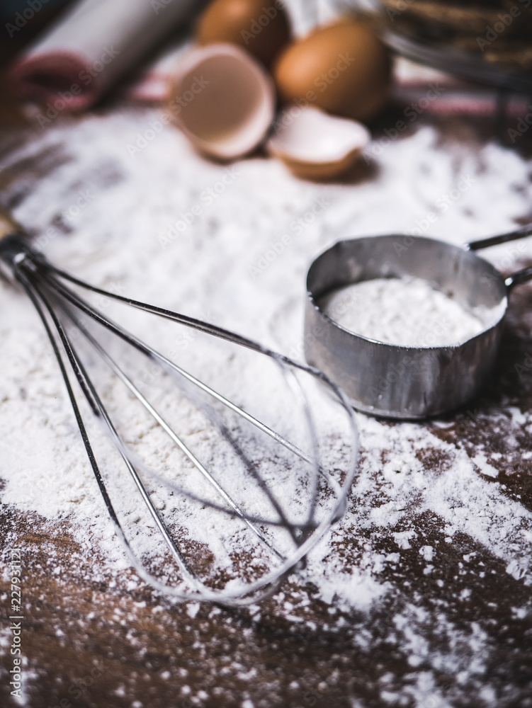 Fototapeta premium Pastry Baking Accessories Bakery Background with flour and whisk. Ingredients for the preparation of bakery products.