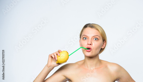 Healthy lifestyle and organic nutrition concept. Lemonade vitamin beverage. Girl drink fresh juice whole lemon fruit with cocktail straw. Benefits of drinking lemon water in morning empty stomach