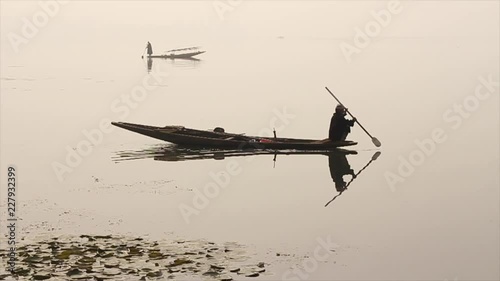 boatman rowing his boat on a lake in Kashmir, India