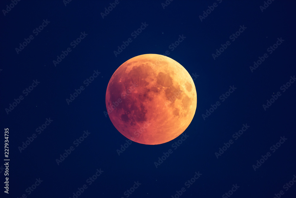 Super Bloody Moon, beginning of full eclipse phase against blue starry sky background