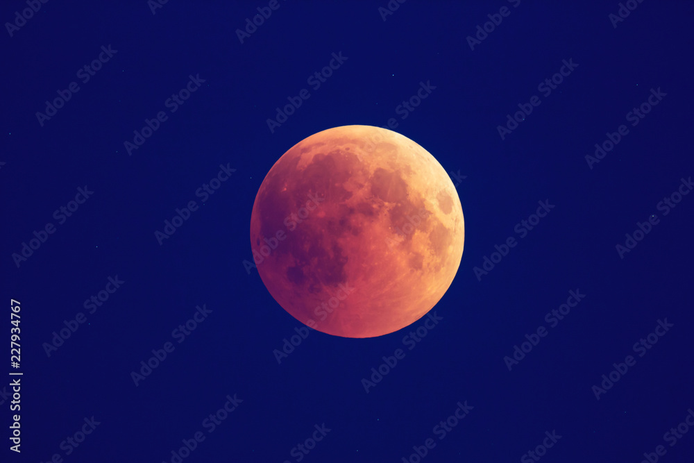 Super Bloody Moon, beginning of full eclipse phase against blue starry sky background