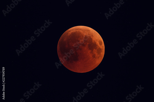 Super Bloody Moon, full eclipse phase against starry sky background