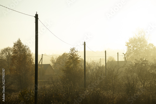 autumn. morning fog thick. the village is visible through the fog. Soft focus.