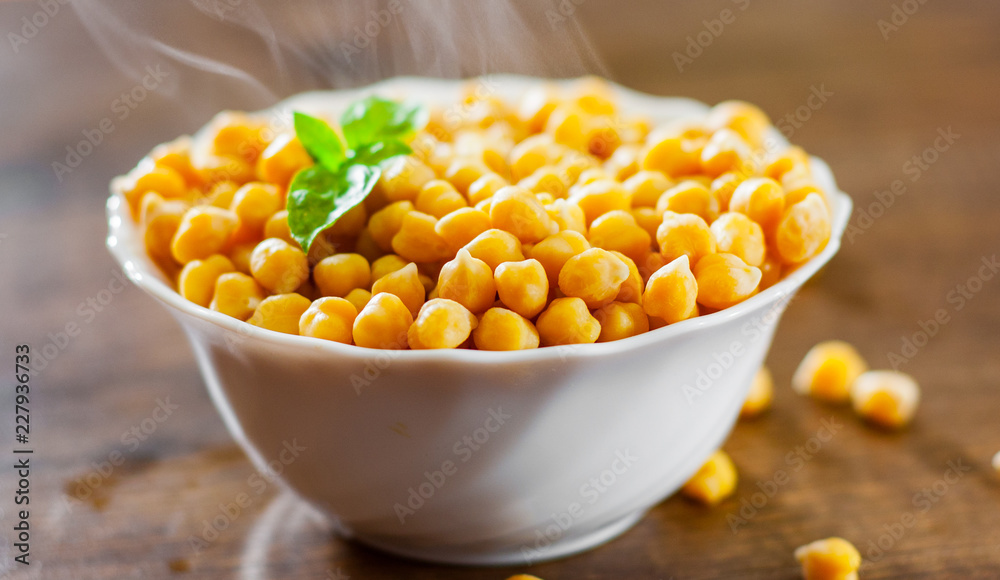 closeup of a bowl with boiled chickpeas on wooden table background closeup of a bowl with boiled chickpeas on wooden table background