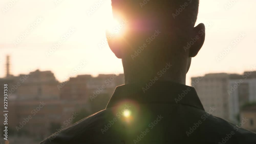 Young african migrant contemplating the city at the sunset- City,urbanization 