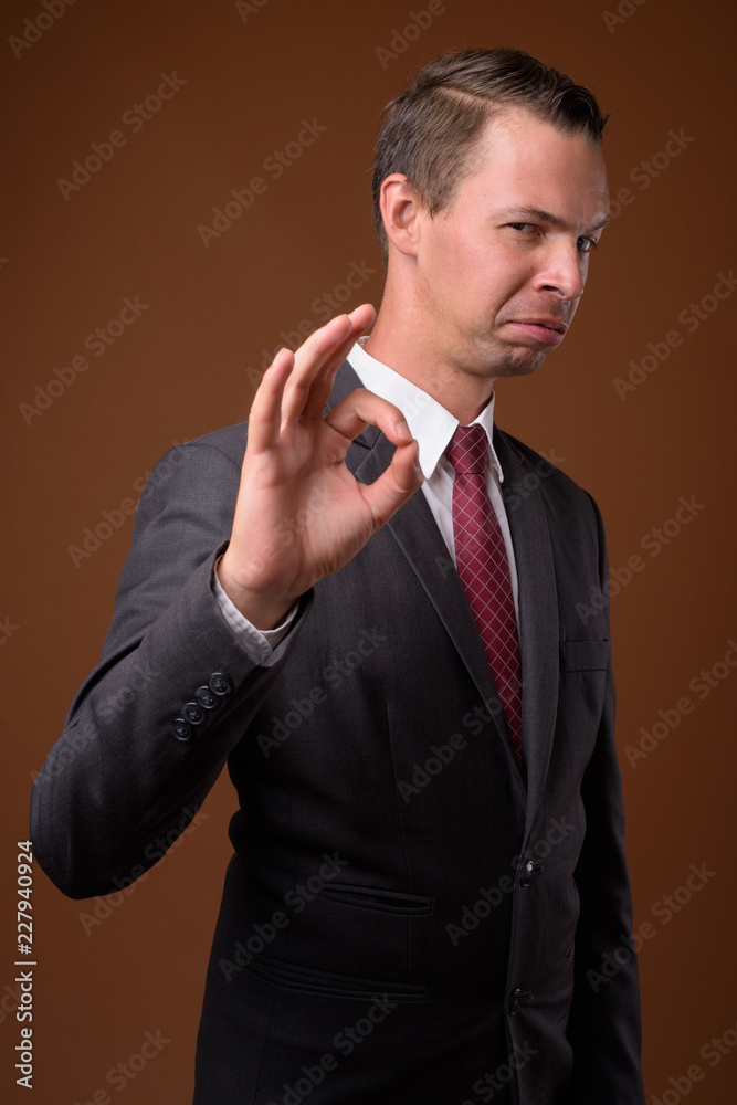 Studio shot of businessman against brown background Studio shot of businessman against brown background
