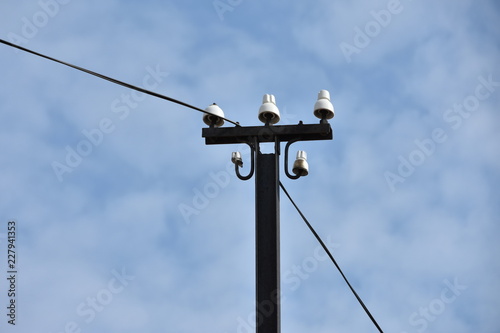 Old electricity pole and wires with background blue sky