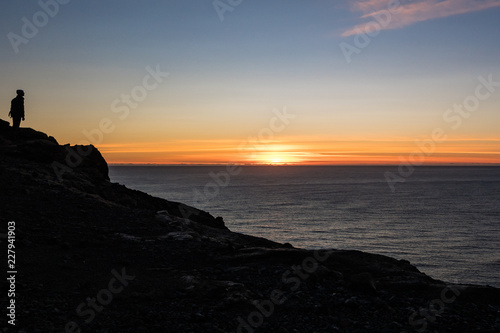 Man on Cliff Watching Sunset