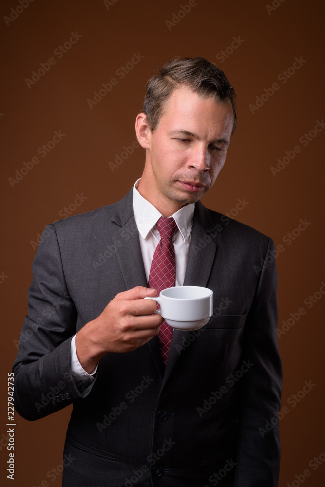 Studio shot of businessman against brown background Studio shot of businessman against brown background