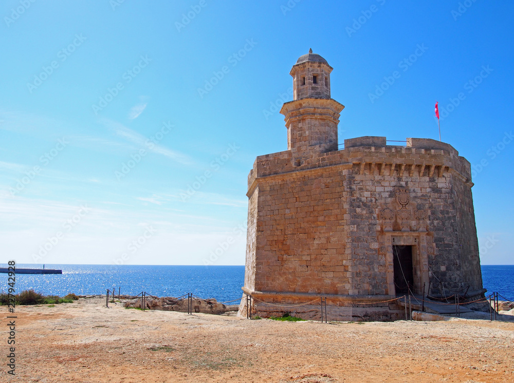 The Sant Nicolau Castle in ciutadella menorca on the cliffs with blue summer sea and blue sky The Sant Nicolau Castle in ciutadella menorca on the cliffs with blue summer sea and blue sky
