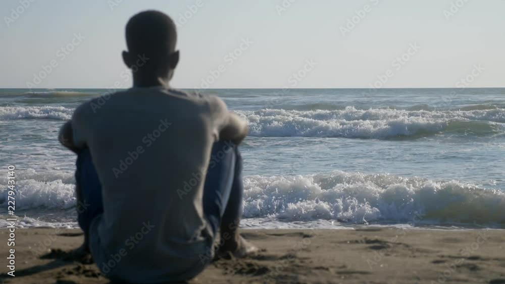 Missing mother Africa. lonely black migrant looking at the ocean thinking Africa Missing mother Africa. lonely black migrant looking at the ocean thinking Africa