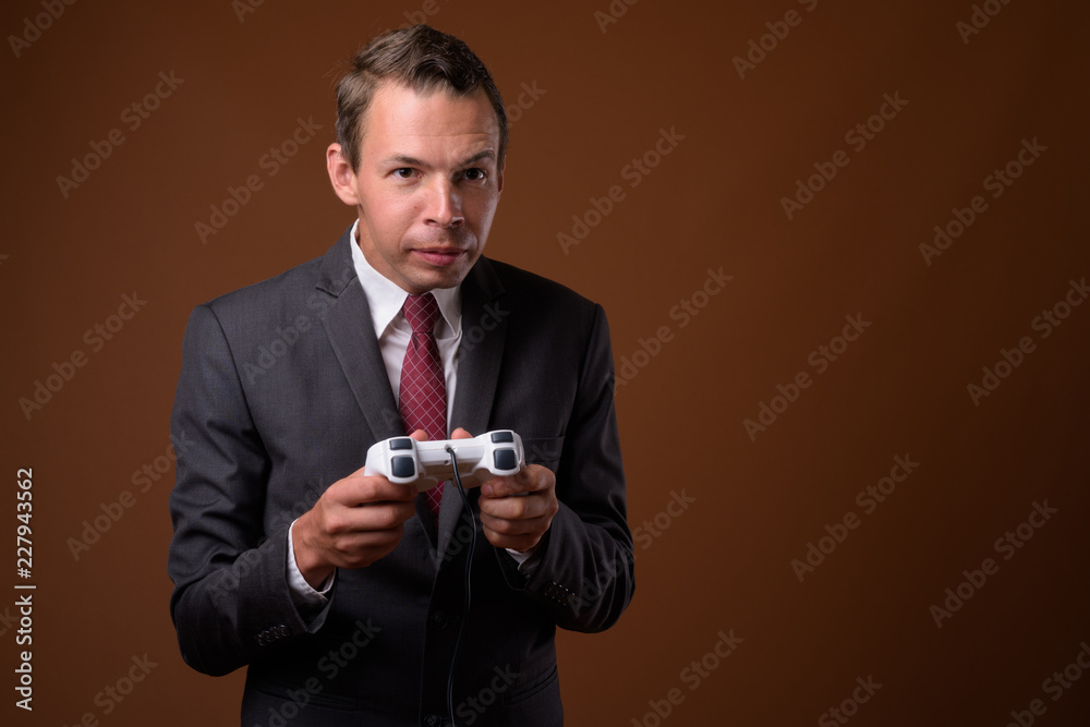 Studio shot of businessman against brown background Studio shot of businessman against brown background