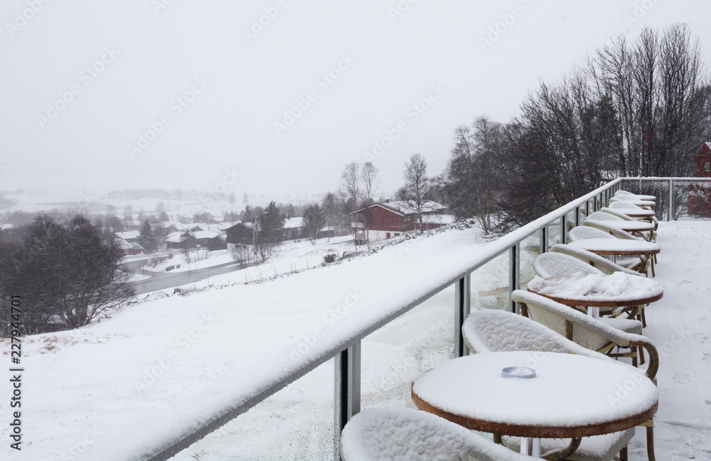 snowy weather. outdoor cafe, tables and chairs on the terrace covered with snow. snowy weather. outdoor cafe, tables and chairs on the terrace covered with snow.