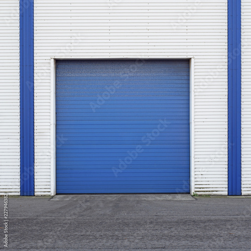 White Industrial warehouse with blue door for trucks