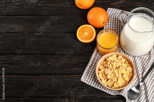 Bowl with healthy cornflakes for breakfast served on dark table. Space for text