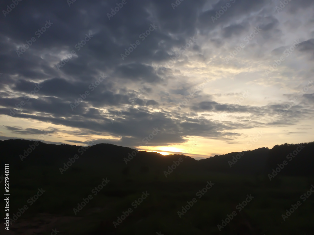 Silhouette of mountain under evening sky with dark clouds and sunsets. Silhouette of mountain under evening sky with dark clouds and sunsets.