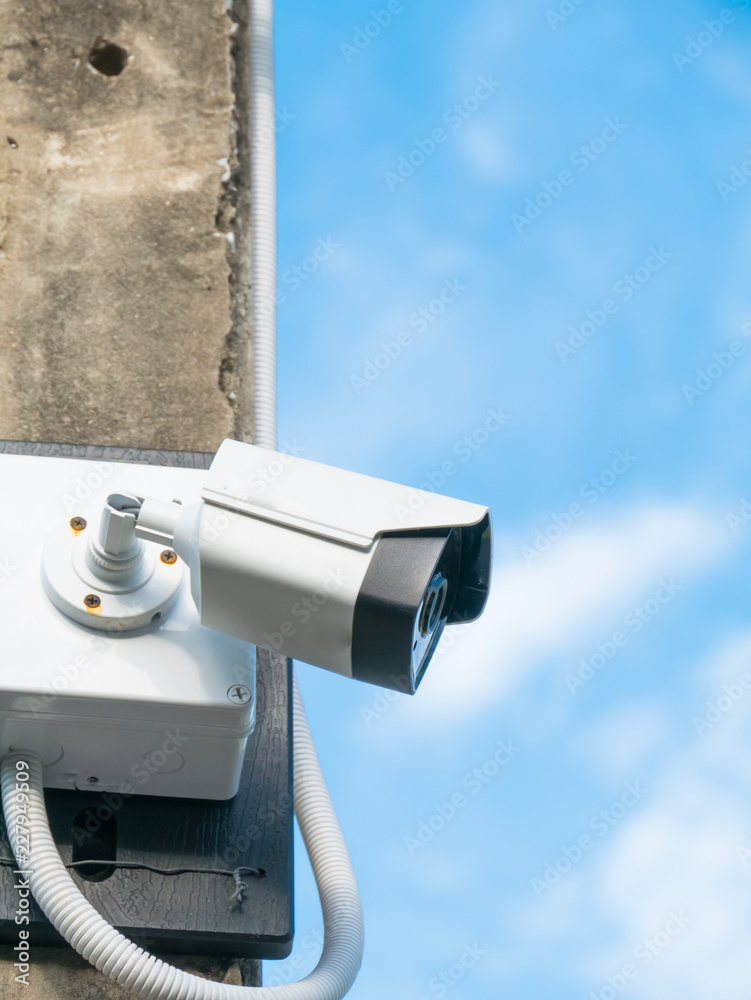 closed-circuit camera on white clouds background, closed-circuit camera on electric pole,