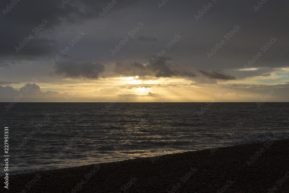 Morning sunrise with sun rays shining through clouds at Aldeburgh
