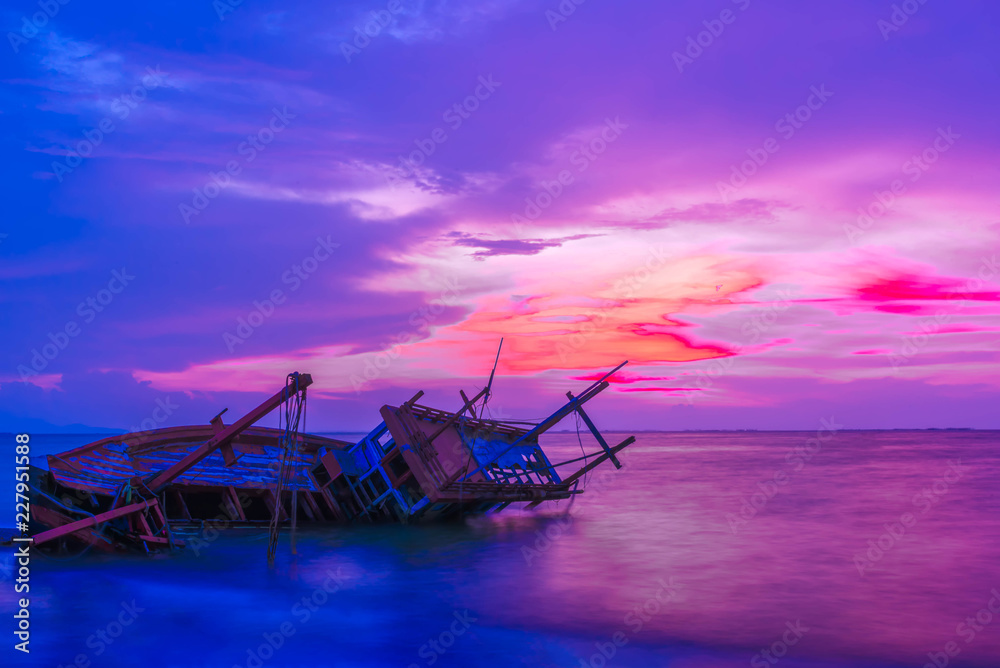Broken fishing boat on seacoast in sunset, Thailand.