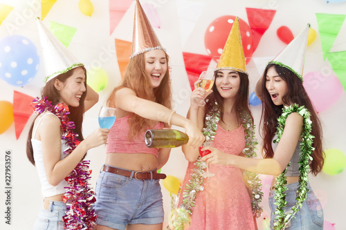Young beautiful women celebrate holiday party and dancing.Friendship wearing dress,casual shorts and T-shirt,having fun,drink champagne and alcohol cocktails in holiday.Pastel tone.