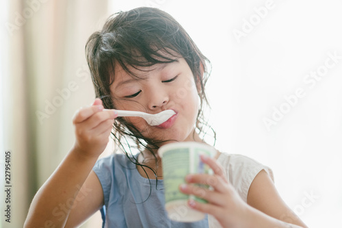 Children is eating yogurt in the morning.
