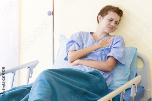 Beautiful young woman patient with neck pain on hospital bed room.Copy space.