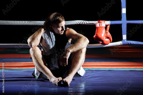 Professional boxer having break during training in ring.