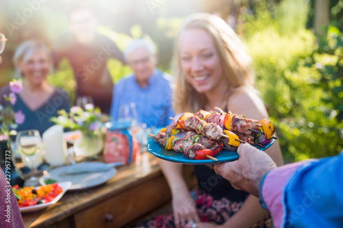 cheerful family gathered around a table for a bbq in the garden