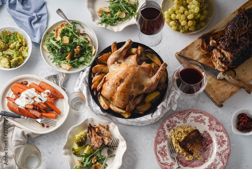 Big festive dinner with roasted chicken and various garnishing. Overhead view, celebration concept