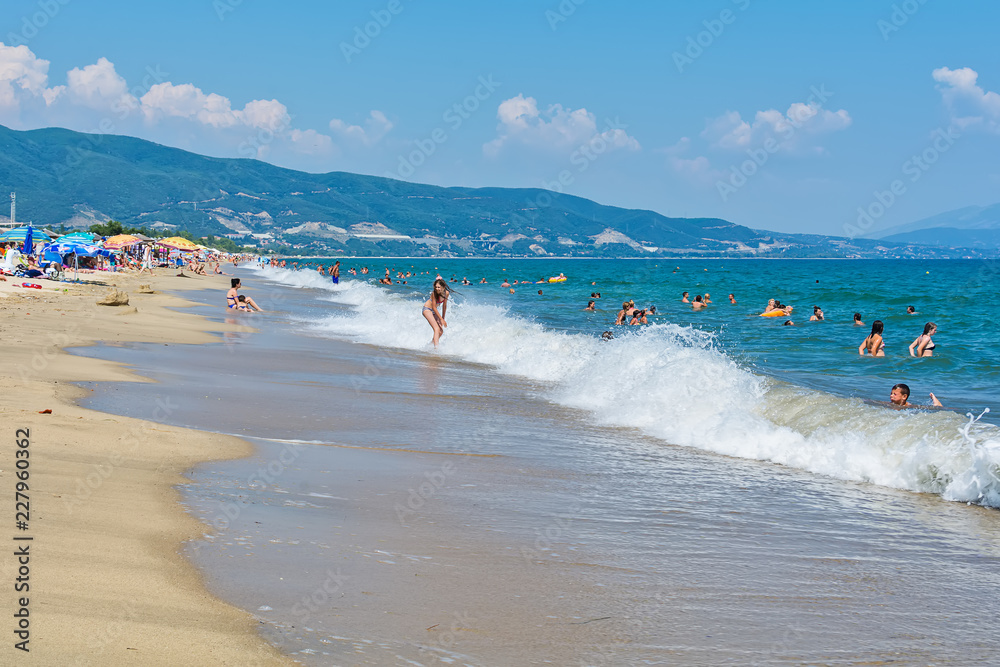 Fototapeta premium Asprovalta, Greece - August 20, 2018: Asprovalta and New Vrasna resort, Asprovalta beach. Sea view to Asprovalta at the foot of the green hills.