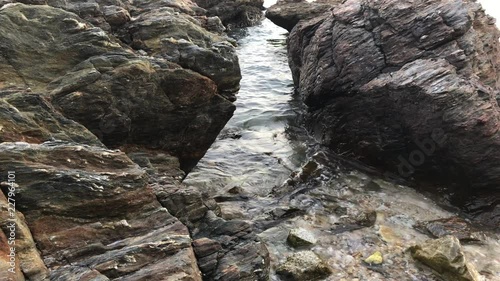 Sea waves break up on the rocks, close-up shot.