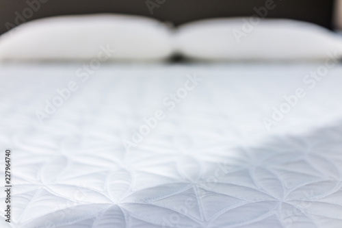 Closeup of mattress on display in store abstract background with nobody, new clean soft spring top, two pillows photo