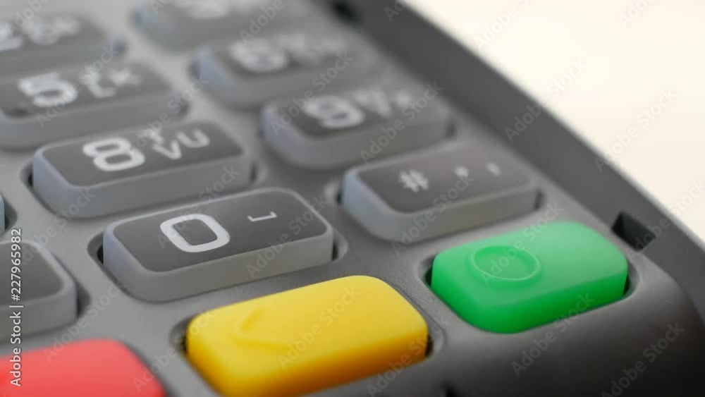 Hand with credit card swipe through terminal for sale and paying for order. Finger entering the PIN code